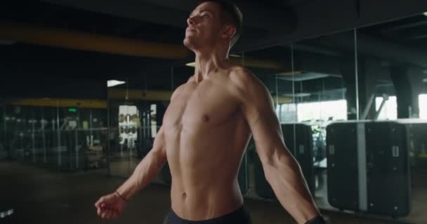잘생긴 남자는 근육을 보여줍니다 남성은 체육관에서 운동을 — 비디오