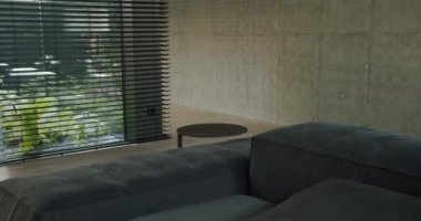 Dinlenme odasının iç kısmı, rahat kanepe, metal sehpa ve modern kır evinin panjurlu penceresi..