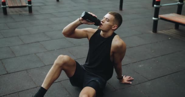 Sportlicher Mann Der Beim Training Pause Macht Auf Dem Boden — Stockvideo