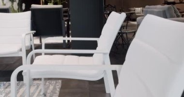 Minimalist sandalyesi ve masası olan beyaz teras mobilyası. Bahçe mobilyaları, Modern Lüks Villa. Minimalist daire. Açık masa ve bahçe parkı için sandalyeler. Lüks villa için modern sandalyeler.