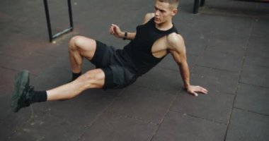 Atletik adamın dışarıda yoğun bir antrenmanı var. Genç kaslı erkek spor alanında çapraz antrenman yapıyor ve egzersiz yapıyor. Etkin yaşam tarzı kavramı