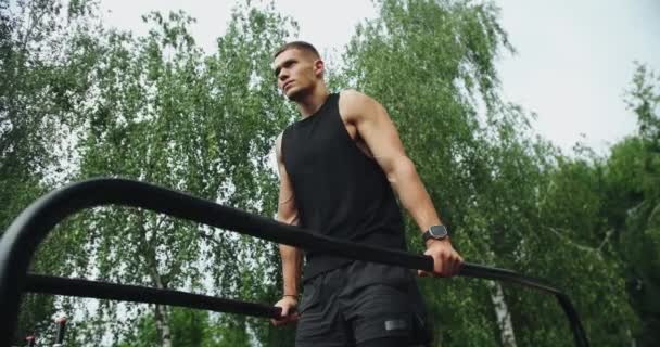 Atletische Man Heeft Training Opknoping Trek Aan Parallelle Bars Buiten — Stockvideo