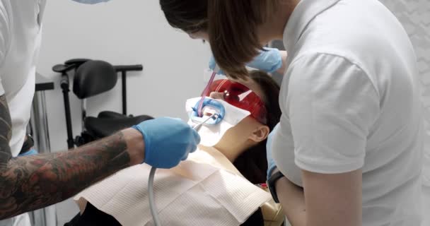 口腔衛生と予防的洗浄 歯科での衛生歯の洗浄手順で女性患者 歯科現代のクリニックで患者のための歯の洗浄を行う歯科医 近代歯科医院 — ストック動画