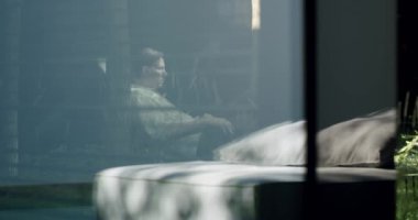 Genç çift dışarıda dinleniyor. Yazlık evin arka bahçesindeki koltuklarda oturan erkek ve kadın güneşli yaz günlerinde doğada rahatlarlar. Hafta sonu konsepti