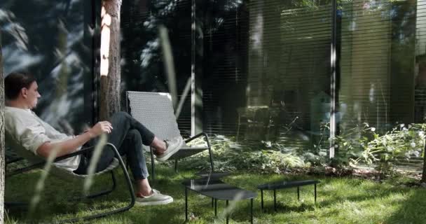 Jovem Sentado Descansando Cadeira Lounge Livre Perto Moderna Casa Campo — Vídeo de Stock