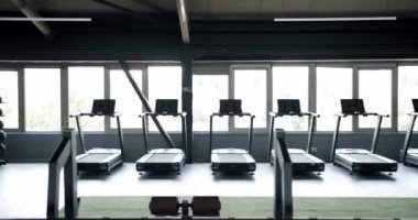 Spor salonu, modern koşu bantları ve spor için spor aletleri. Çalışan makineleri olan boş spor kulübü