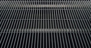 Erkek ayağına yakın, şık ayakkabılı metal şebekede yürüyor. Modern evin terasında paslanmaz çelik döşeme inşaatı. Dışarıdaki döşeme kanalizasyonu.