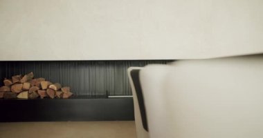 Detaylar iç kısımda, odun yığını duvar boşluğunda. Oturma odasında minimalist tarzda odun yığını depolama fikri. Modern yazlık evde dekor ögesi
