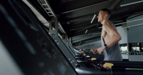 Widok Boku Sportowca Muskularnym Ciałem Ćwiczącego Nowoczesnej Siłowni Biegającego Bieżni — Wideo stockowe