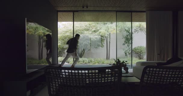 年轻人打开了现代村舍的玻璃滑动门 现代度假之家 家具时尚 室内装潢 园林景观尽收眼底 — 图库视频影像