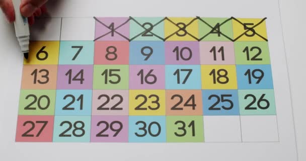 Person Hand Black Marker Cross Dates Colorful Paper Month Calendar — Stock Video