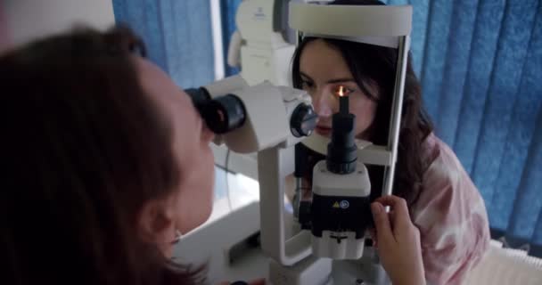 与眼科医生预约看病的病人 眼科医生检查视力的病人在橱柜中使用缝隙灯 博士用专业诊断设备进行眼科测试 — 图库视频影像