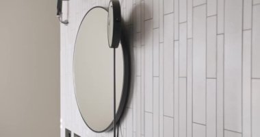 Yuvarlak aynalı modern iç mekan, beyaz renkli minimalist iç mekan banyo aksesuarları, ayna ve lamba modern iç mekan.