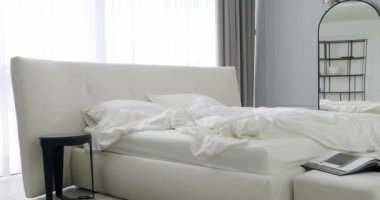 Zarif iç tasarım. Minimalist yatak odası. Yatak odası içi ve bir sürü yastıklı duble yatak. İç dekorasyonun minimalist tarzı. Beyaz Kral yatağı olan zarif ve basit bir yatak odası. Gayrimenkul.