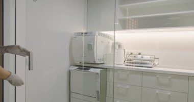 Manikürcü asistanı sterilizasyon odasında manikür aletlerini güzellik salonunda tıbbi malzemelerle hazırlayıp dezenfekte ediyor.. 