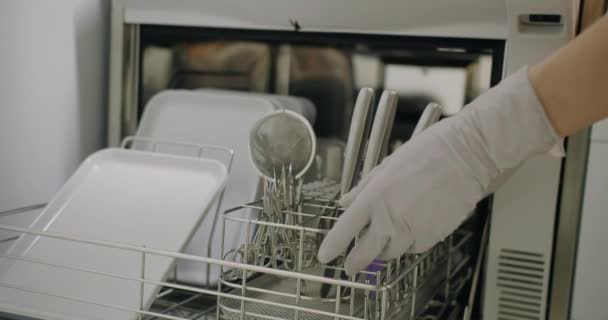 手袋の女性の手は消毒剤洗濯機からきれいで 滅菌性のマニキュアツールを取り出します プロの医療機器を使用したネイルケア手順のための機器を準備するマネジスト — ストック動画