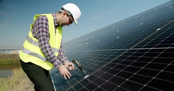 太阳能电池板的连接和安装 连接太阳能电池板的技术员 为金属平台系统安装太阳能电池板的电气螺丝刀技师 — 图库视频影像