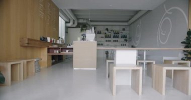 Modern kahve dükkanı, şık iç dekorasyonu, oturaklı ahşap masalar ve bar tezgahı. Minimalist tasarımlı, kapalı bir kafe.