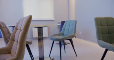 Kafede modern iç mekan, yuvarlak yemek masaları ve rahat koltuklar. Çağdaş mobilyaları olan bir kafede minimalist stil..