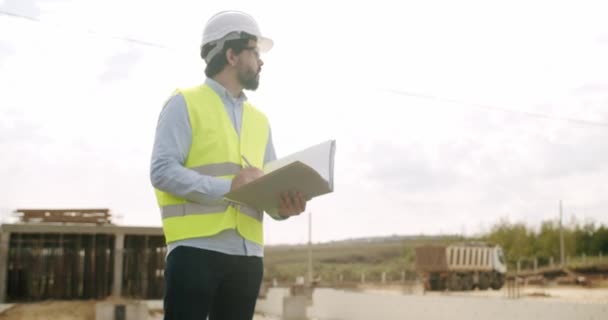 Man Ingenieur Beschermende Helm Vest Uniform Staan Bouwplaats Het Controleren — Stockvideo