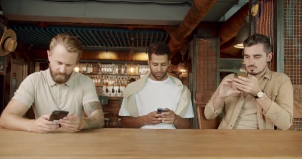 Gruppe Umtriebiger Männerfreunde Die Der Kneipe Sitzen Und Alle Smartphone — Stockvideo