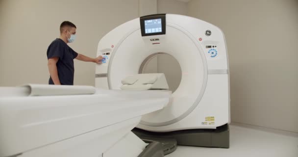 医師の放射線科医が病院でMriまたはCtマシンをオンにする 男性は クリニックで診断のための近代的なX線スキャナー医療機器を準備します — ストック動画