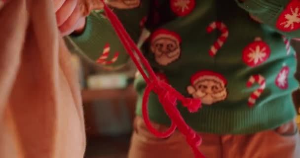 穿毛衣的圣诞老人的衣服带着礼物 打开袋子 在家里祝贺你 圣诞假期时 男性手打开装有礼物的袋子时被剪下的照片 除夕概念 — 图库视频影像
