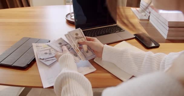 在家里坐在办公桌前 拿着笔记本电脑的时候 看到女人在数钱和计划预算 女性领取工资 节约资金的概念 分析收入收入 — 图库视频影像