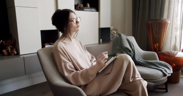 Femme Réfléchie Assise Sur Fauteuil Confortable Prenant Des Notes Dans — Video