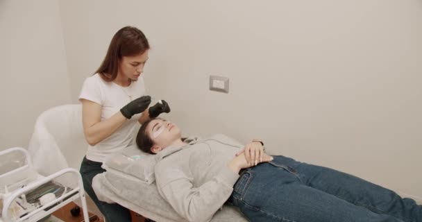 Güzellik Uzmanı Güzellik Salonundaki Kadın Müşteriye Kirpik Boyama Prosedürü Uyguluyor — Stok video