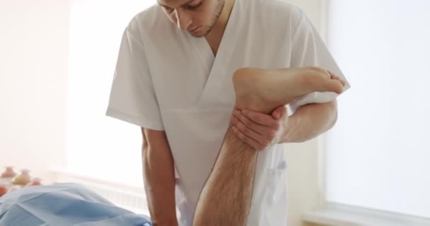 Osteopata Leczy Mężczyzn Klinice Ręczne Ujęcie Męskiego Masażysty Rozciągającego Podniesioną — Wideo stockowe