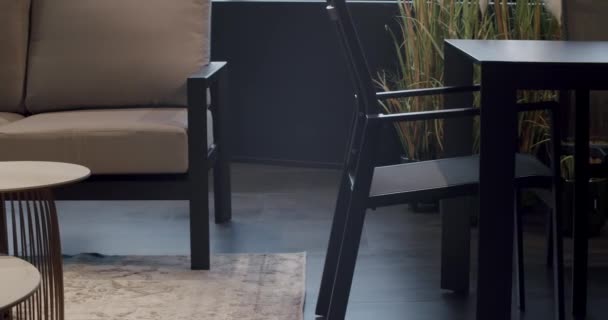 豪華なヴィラ ミニマリストの椅子とテーブル付きの夏のテラスの家具のための現代の黒い椅子 庭のための家具 モダンな高級ヴィラ ミニマリストのアパート ガーデンパーク用屋外テーブルチェア — ストック動画