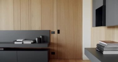Ahşap duvarlı ve gri mobilyalı modern Minimalist oturma odası. Modern raflar ve kitaplarla Minimalist Ev İçi. Modern Mobilya, Lüks Şık Oda Ahşap modern kapılı.