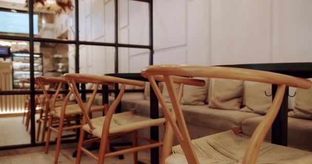 木製の椅子とテーブルを閉じる エコフレンドリーなカフェ 空のダイニングファブリックと木製の椅子 カフェのモダンな木製ファブリックチェアとテーブル家具 — ストック動画