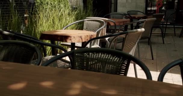 ストリートカフェ モダンテラス 夏の朝に空いたカフェ モダンな屋外カフェ 空のレストラン 通りのカフェで黒のモダンなカリスマの木のテーブル — ストック動画