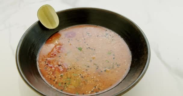 美味的蔬菜汤在白色背景下旋转 奶油西红柿和蔬菜汤 配料和石灰 底色为黑色 底色为白色 — 图库视频影像
