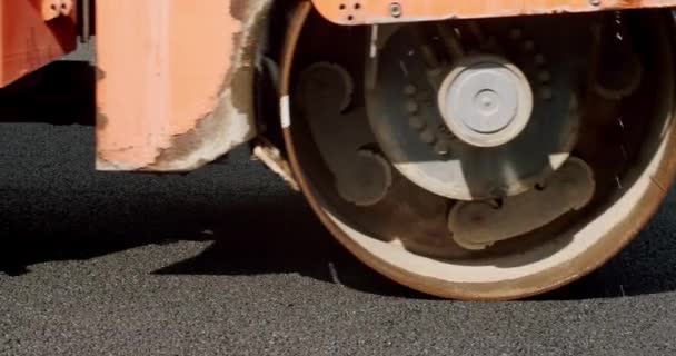 道路建筑工地的沥青摊铺机 沥青路面铺设 公路建设沥青摊铺机正在铺设一层新的沥青 公路滚轮在一条新的公路上行驶 — 图库视频影像