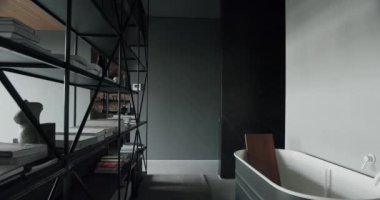 Çatı katının içinde şık bir banyo, beyaz musluğu ve bölme yeri olan modern bir küvet. Kitaplığı ve banyosu olan geniş bir daire. İç tasarım fikri 