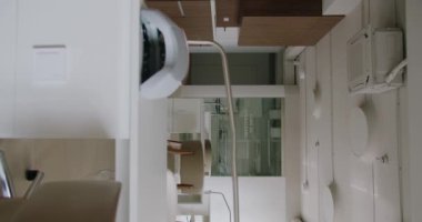 Modern iç mimarisi olan manikür salonu, rahat koltuklu beyaz masa, çivi lambası ve profesyonel ekipman. Rahat bir iş yeri. Minimalist tasarım. Dikey video