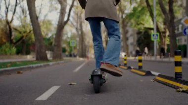 Şehir yolunda elektrikli scooter kullanan şık bir kadının arka planı. Kot pantolonlu ve ceketli genç bir kadının ekolojik taşıma araçlarını kesmiş. Aktif boş zaman. Kentsel yaşam tarzı