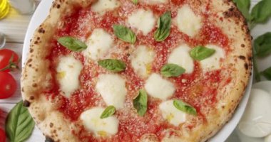 Domates soslu margherita pizzası, mozzarella peyniri ve restoranda dönen tabakta taze fesleğen. Geleneksel margarita ve malzemelerin yakınlaştırılması.