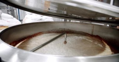 Bira fabrikasındaki paslanmaz çelik tankta buğday fermantasyonu. Bira demleme işlemi. Açık kapaklı bira fabrikası ekipmanları. Bira imalatı. Fermantasyon ve olgunlaşma için varil taşıyıcı.