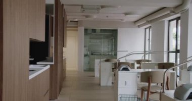 Modern iç mekanlı manikür salonu, rahat sandalyeli beyaz masalar ve manikür prosedürü için profesyonel ekipmanlar. Rahat işyerleri olan geniş bir güzellik salonu.
