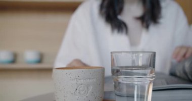 Kadın yemek molası veriyor, masada oturuyor, çay içiyor ve kafede dinlenirken dergi okuyor. Kadın ziyaretçi manzaralı, rahat bir restoranda kahvaltı yapıyor. Yaşam tarzı kavramı