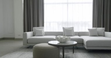 Beyaz mobilyaları ve yuvarlak masaları olan modern minimalist oturma odası. Köşedeki kanepe. Moda mobilyalar. Minimalist İç İşleri. Samimi Modern Mobilya Tasarımı. Lüks Zarif Oda