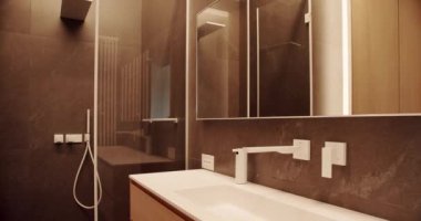 Lüks Banyo İçi, kahverengi renkli minimalist iç mekan, banyo aksesuarları, ayna ve duş başlığı, küvet modern tasarım. Sıcak, beyaz bir daire. Basitlik tasarımı olan modern banyo..