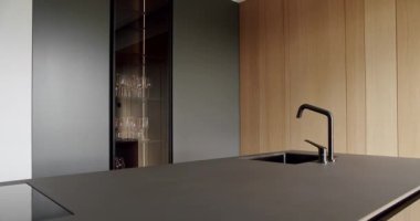 Bir adası olan lüks bir mutfak. Açık Ahşap Duvar ve Zemin. Modern mutfak ve bar kahverengi sandalyeler minimalist dairede mutfak odasında. Minimalist yemek masası olan modern mutfak odası..