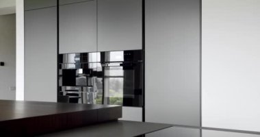 Bir adası olan lüks bir mutfak. Modern mutfak ve bar kahverengi sandalyeler minimalist dairede mutfak odasında. Minimalist yemek masası olan modern bir oda. Modern lavabolu Ev Mutfağı.