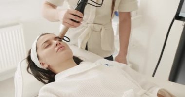 Koruyucu gözlüklü güzel kadın, cilt tazeleme konsepti. Güzellik uzmanı kozmetik uzmanı lazer teknolojisiyle kısmi mikronedle mezoterapi gençleştirme işlemi yapıyor. Güzellik tedavisi.