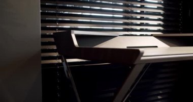 Kapatın ve rahat çalışma odasındaki minimalist deri sandalyeli modern masayı detaylandırın. Oda palmiyesi dekoru. Minimalist siyah panjurlar. Güzellik odasındaki aksesuar. Deri koltuklu ve masalı..